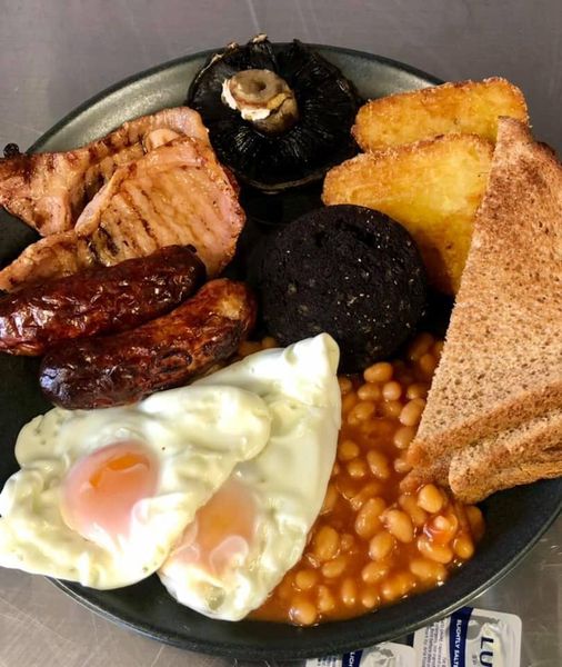 full english breakfast with eggs, sausages, bacon, mushroom, black pudding, beans and toast