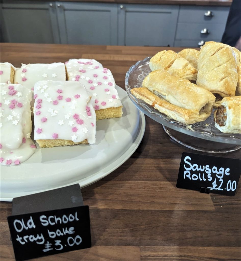 sausage rolls and cake with white icing and sprinkles